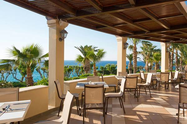 Außenterrasse des Iberostar Creta Panorama & Mare Hotels mit Blick auf das Meer und Palmen