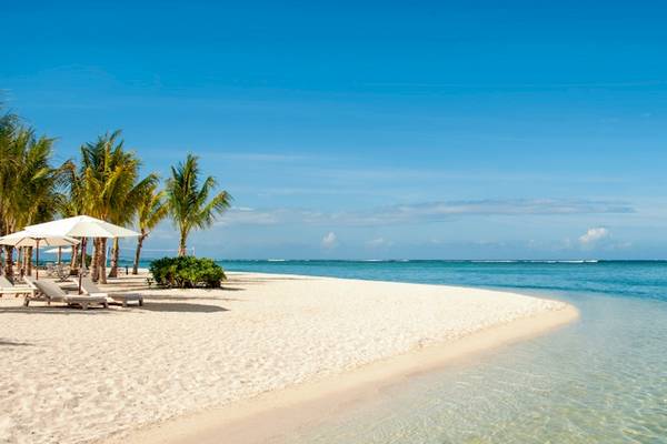 Strand des JW Marriott Mauritius Resorts mit weißen Liegestühlen und Schirmen