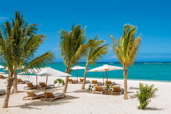 JW Marriott Mauritius Resort Strand mit weißen Sonnenschirmen und Liegen