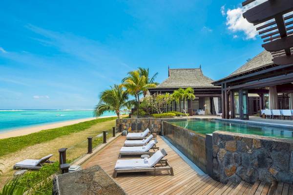 Außenpool und Loungebereich des JW Marriott Mauritius Resorts mit Blick auf den Ozean.