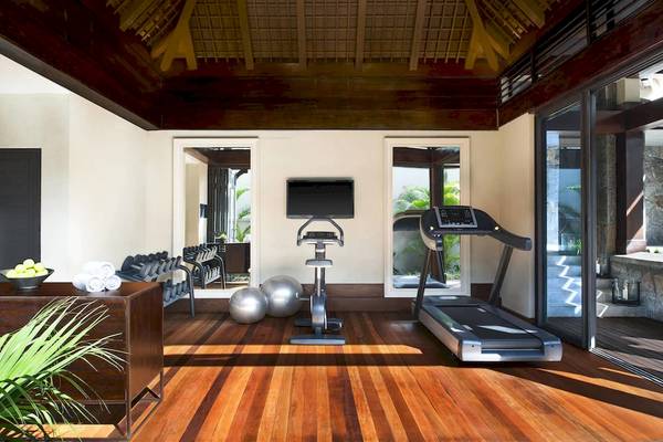 Fitnessraum im JW Marriott Mauritius Resort mit Laufband, Hanteln und Trainingsbällen.