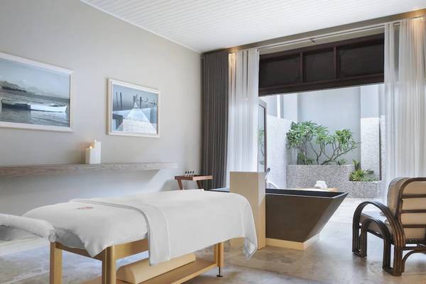 Spa-Zimmer im JW Marriott Mauritius Resort mit Massagetisch, Badewanne und Aussicht.