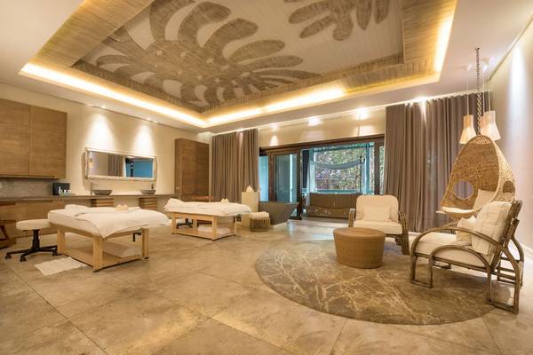 Wellnessbereich im JW Marriott Mauritius Resort mit zwei Massagetischen, Sesseln und einer Hängematte.
