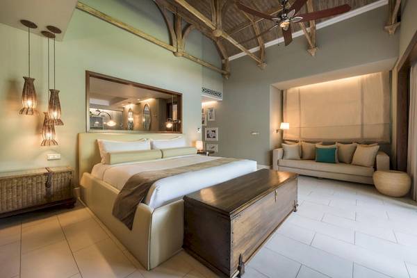 JW Marriott Mauritius Resort Hotelzimmer mit Bett, Sofa, Deckenventilator und Lampen.