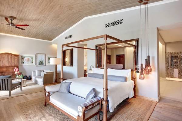 Schlafzimmer im JW Marriott Mauritius Resort mit vier Poster-Bett, Sofa und Deckenventilator