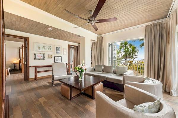 Wohnbereich im JW Marriott Mauritius Resort mit einem Sofa, einem Tisch und einem Blick auf den Ozean.