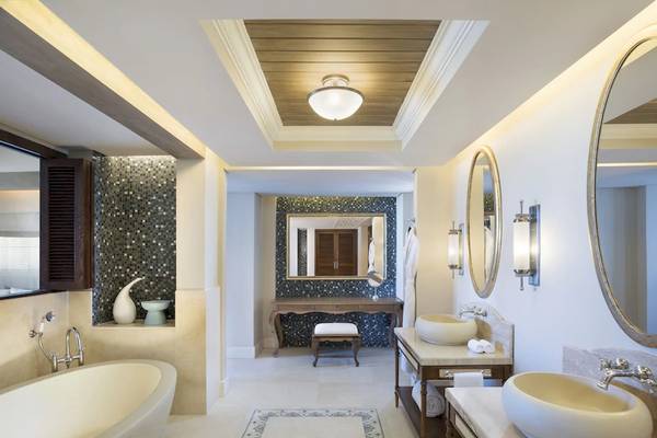 Innenansicht eines Badezimmers im JW Marriott Mauritius Resort mit Badewanne, Waschbecken und Spiegel.