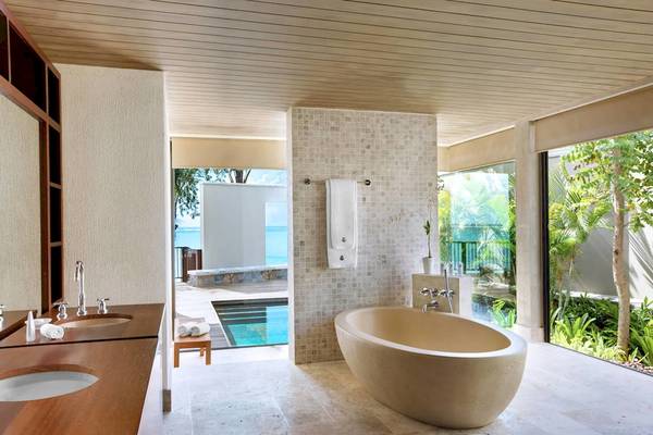 Badezimmer im JW Marriott Mauritius Resort mit Badewanne und Ausblick auf den Pool.