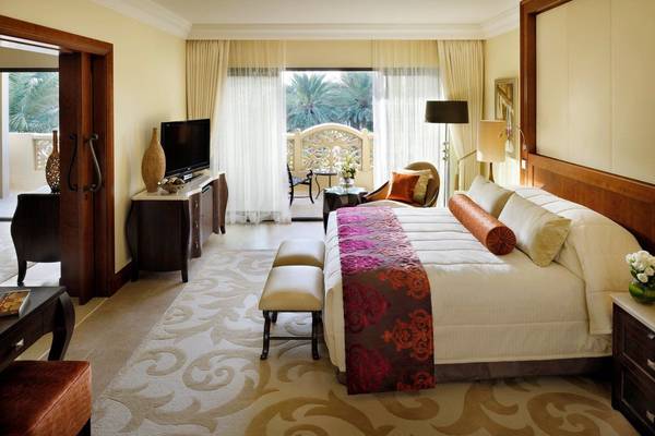 Luxuriöses Hotelzimmer im Palace at One & Only Royal Mirage mit großem Bett, Fernseher und Balkon.