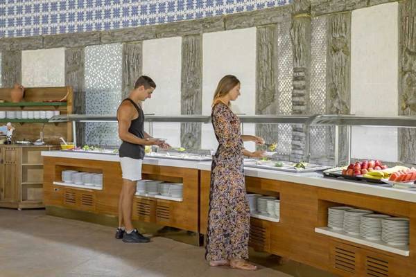 Ein Mann und eine Frau stehen vor einem Buffet im Royal Holiday Palace Hotel.