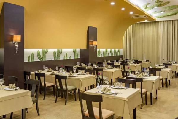 Restaurant im Royal Holiday Palace mit gedeckten Tischen und Kaktus-Wanddesign.