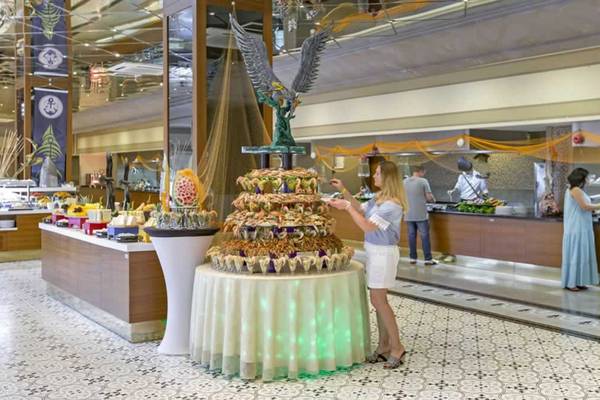 Eine Frau steht vor einem großen Buffet-Tisch im Royal Holiday Palace Hotel.