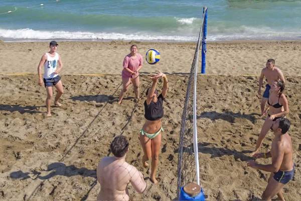 Gruppe spielt Volleyball auf dem Sandstrand des Royal Holiday Palace