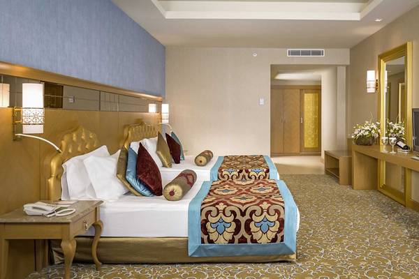 Doppelzimmer im Royal Holiday Palace mit zwei Betten, Dekor und Fernseher.