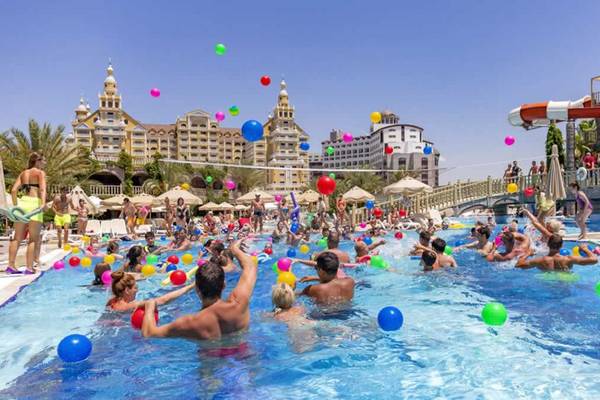 Gäste feiern eine Poolparty im Royal Holiday Palace Hotel mit vielen bunten Bällen.