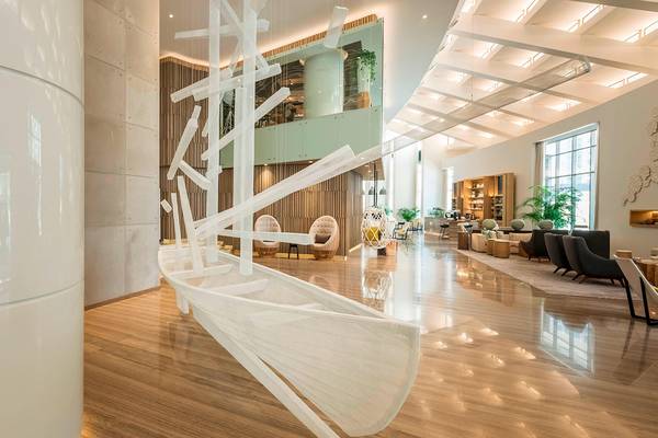 Innenansicht der Lobby des Le Royal Meridien Beach Resort mit einer weißen Skulptur und Holzboden.