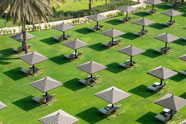 Luftaufnahme des Le Royal Meridien Beach Resorts mit vielen Sonnenschirmen und Liegestühlen auf dem Rasen.