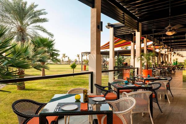 Außenterrasse im Le Royal Meridien Beach Resort mit Blick auf eine Rasenfläche und Palmen