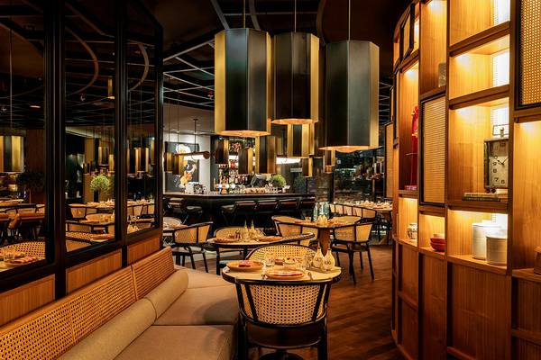 Innenraum des Restaurants im Le Royal Meridien Beach Resort mit Tischen, Stühlen und Bar.