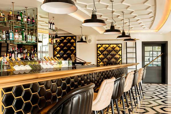 Innenansicht der Bar im Le Royal Meridien Beach Resort mit goldener Theke und schwarzen Lederstühlen.