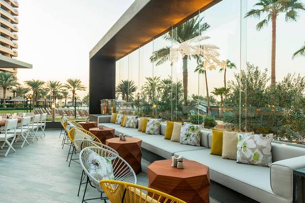 Terrasse im Freien mit Tischen, Stühlen und Sofas im Le Royal Meridien Beach Resort & Spa.