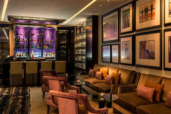 Innenansicht der Bar im Le Royal Meridien Beach Resort & Spa mit Theke, Cocktails, gerahmten Bildern und Möbeln.