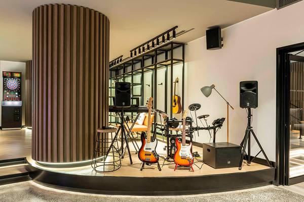 Musikbereich im Le Royal Meridien Beach Resort & Spa mit Gitarren, Klavier und Dartscheibe.