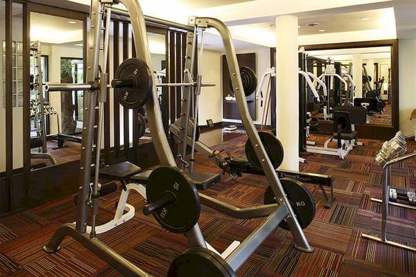 Fitnesscenter im Cape Panwa Hotel mit verschiedenen Geräten wie Hanteln und Laufbändern.
