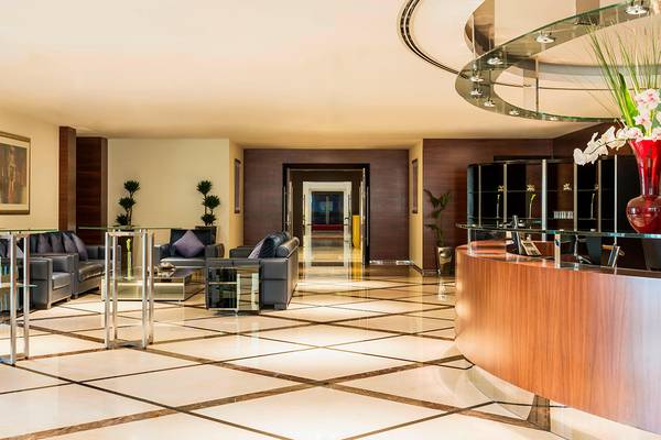 Hotellobby des Westin Dubai Mina Seyahi Beach Resort & Marina mit Empfangstresen, Sofas und Pflanzen.
