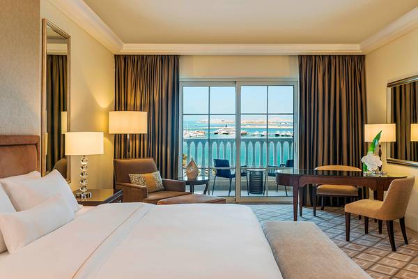 Hotelzimmer mit Meerblick im Westin Dubai Mina Seyahi mit Balkon, Schreibtisch und Schlafbereich.