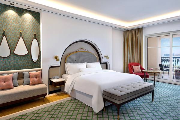 Das Hotelzimmer des Westin Dubai Mina Seyahi Beach Resort & Marina mit Bett, Sofa, Spiegeln und Balkon.