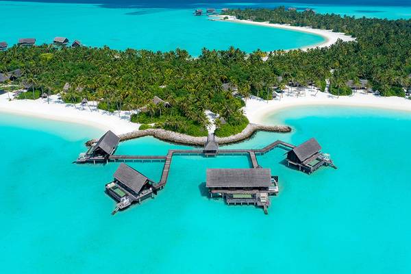 Luftaufnahme des One & Only Reethi Rah Resorts mit Wasservillen im blauen Wasser