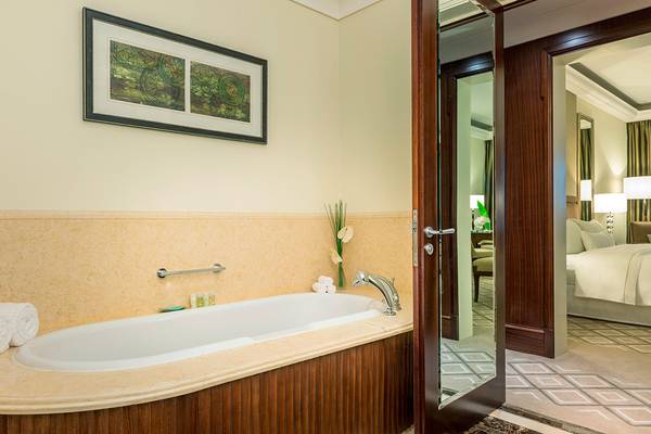 Badezimmer einer Suite im Westin Dubai Mina Seyahi mit Badewanne, Spiegel und gerahmtem Bild an der Wand.