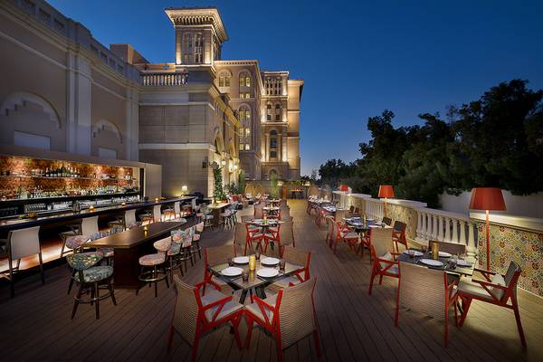 Abendessen auf der Terrasse des Westin Dubai Mina Seyahi Beach Resort & Marina mit Tischen und Stühlen, Lampen und Blick auf das Hotelgebäude.