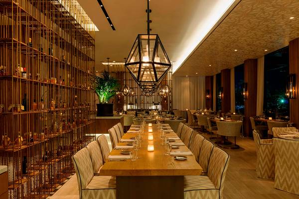 Innenansicht des Restaurants im Westin Dubai Mina Seyahi Beach Resort & Marina mit langen Tischen und weichen Stühlen.