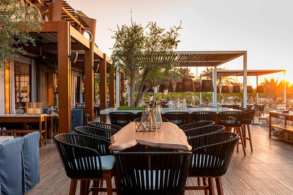 Terrasse des Westin Dubai Mina Seyahi Beach Resort & Marina mit Tischen und Stühlen