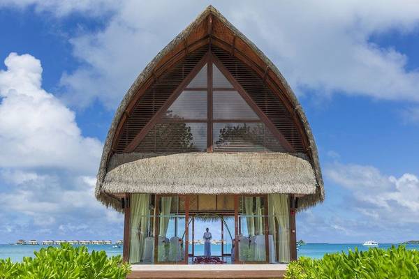 Hochzeitszeremonie im Angsana Velavaru vor dem Meer mit einer Person im Hintergrund.