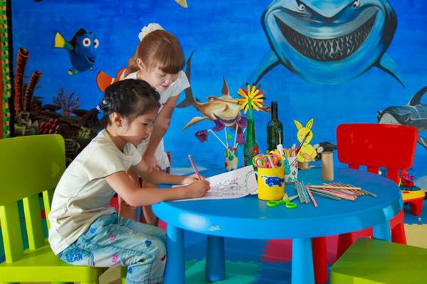 Kinderzimmer im Angsana Velavaru Hotel mit einer Wandmalerei von Haien und Fischen.