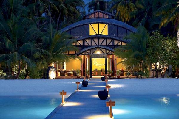 Angsana Velavaru Hotel am Strand bei Nacht mit beleuchtetem Eingang und Wasserweg