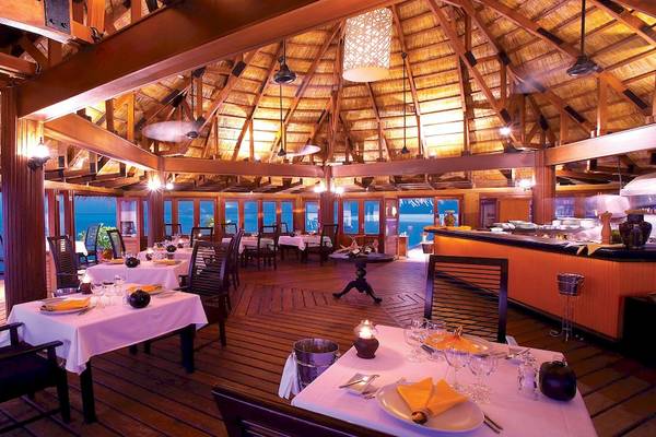 Innenansicht des Restaurants im Angsana Velavaru mit Blick auf das Meer und gedeckten Tischen.