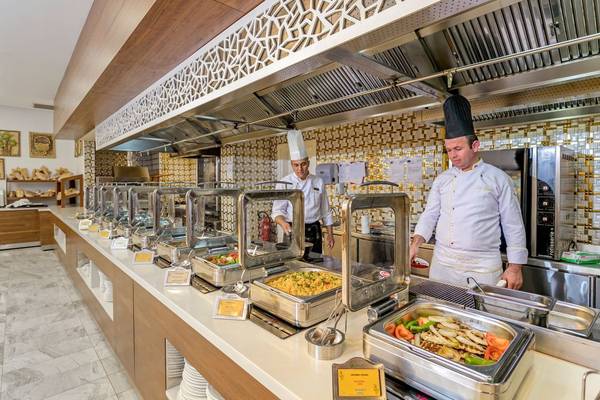 Buffet-Restaurant im Glamour Resort & Spa mit Köchen, die Speisen zubereiten.