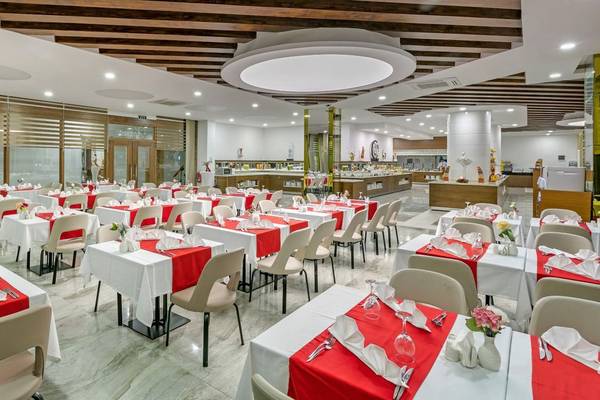 Innenraum des Glamour Resort & Spa mit vielen gedeckten Tischen und Stühlen.