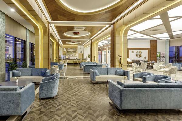 Innenansicht der Lobby des Glamour Resort & Spa mit modernen Möbeln und großen Fenstern.