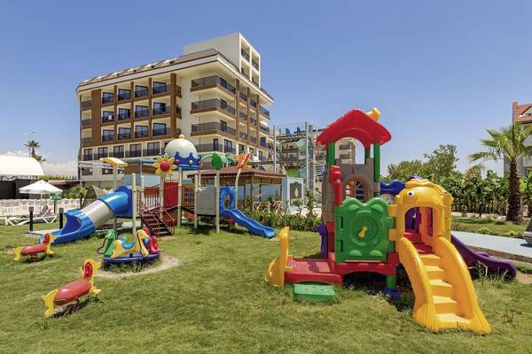 Farbiger Spielplatz vor dem Glamour Resort & Spa mit vielen Spielgeräten und einer grünen Rasenfläche.