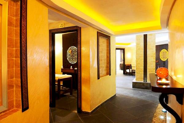 Wellnessbereich im Golden Tulip Taj Sultan Hotel mit gelben Wänden und gefliestem Boden.