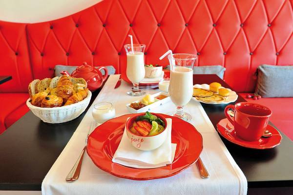 Frühstückstisch im Boutique Hotel Liberata mit Croissants, Joghurt, und Getränken.