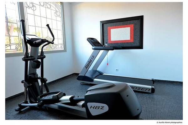 Fitnessraum im Boutique Hotel Liberata mit Läufer und Crosstrainer neben Fenster