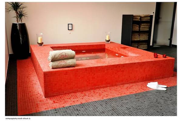 Roter Whirlpool im Boutique Hotel Liberata mit roten Kacheln und zwei Handtüchern.
