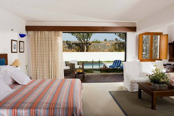 Innenansicht eines Zimmers im Elounda Bay Palace mit Blick auf den Pool.