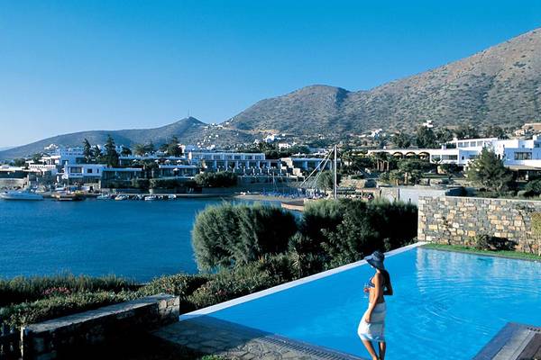 Pool im Elounda Bay Palace mit Blick auf das Meer und die Berge.